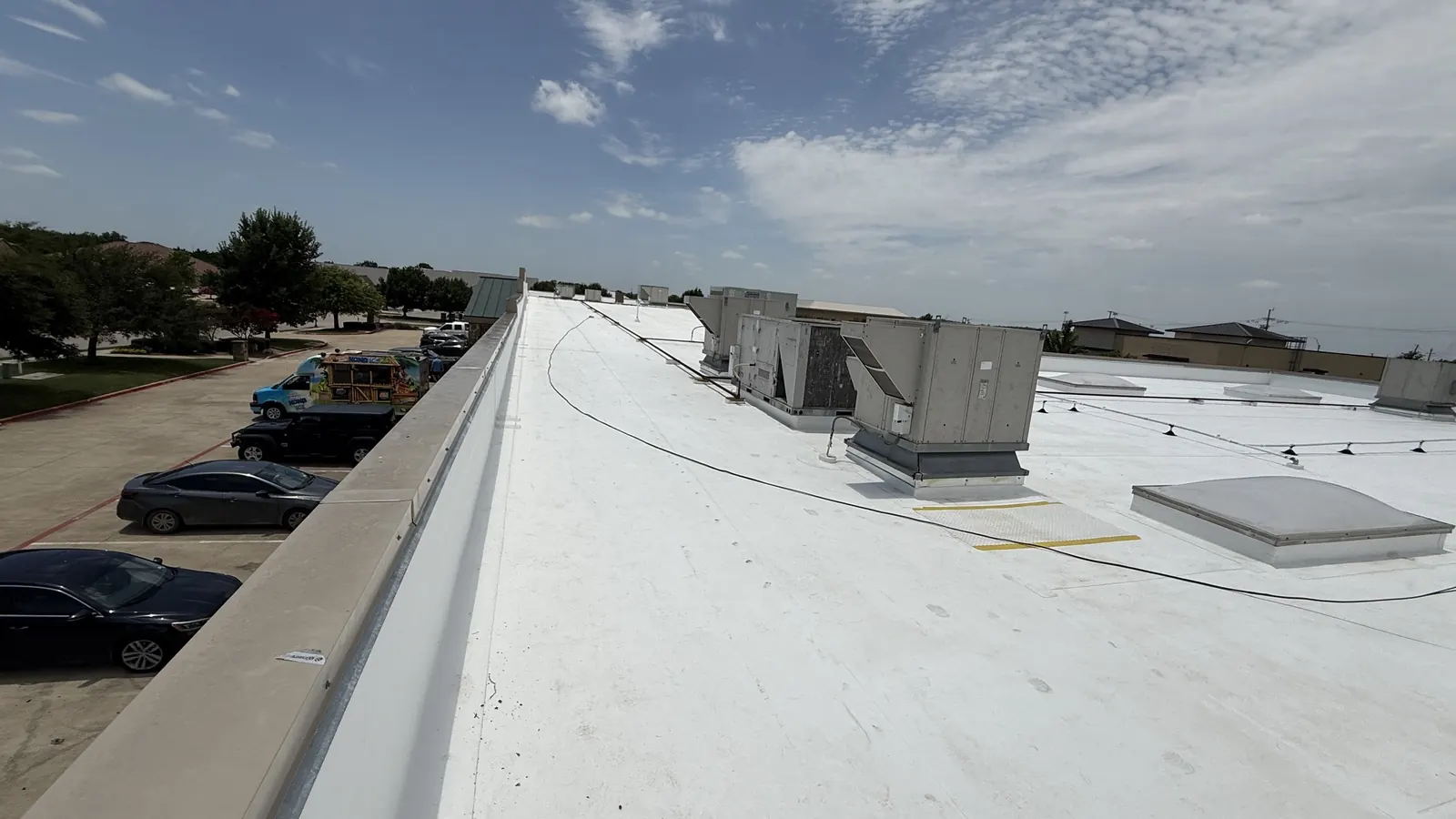 TPO membrane running up a parapet wall under cast stone coping on a commercial roof